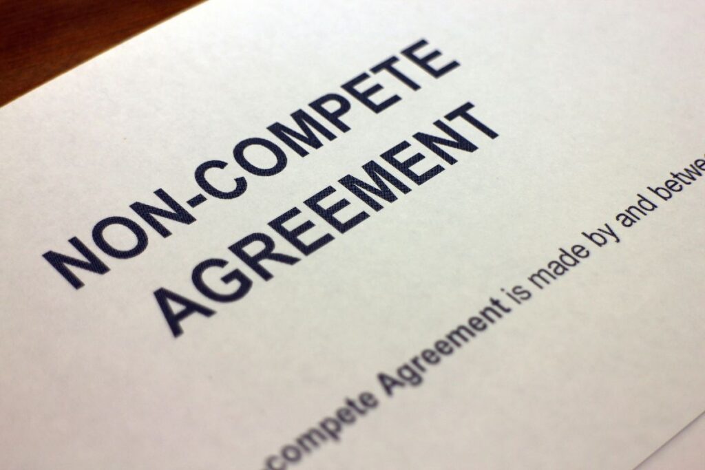 Non-compete agreement document with bold text on a white background. Partial sentence visible at the bottom. Professional and formal setting.